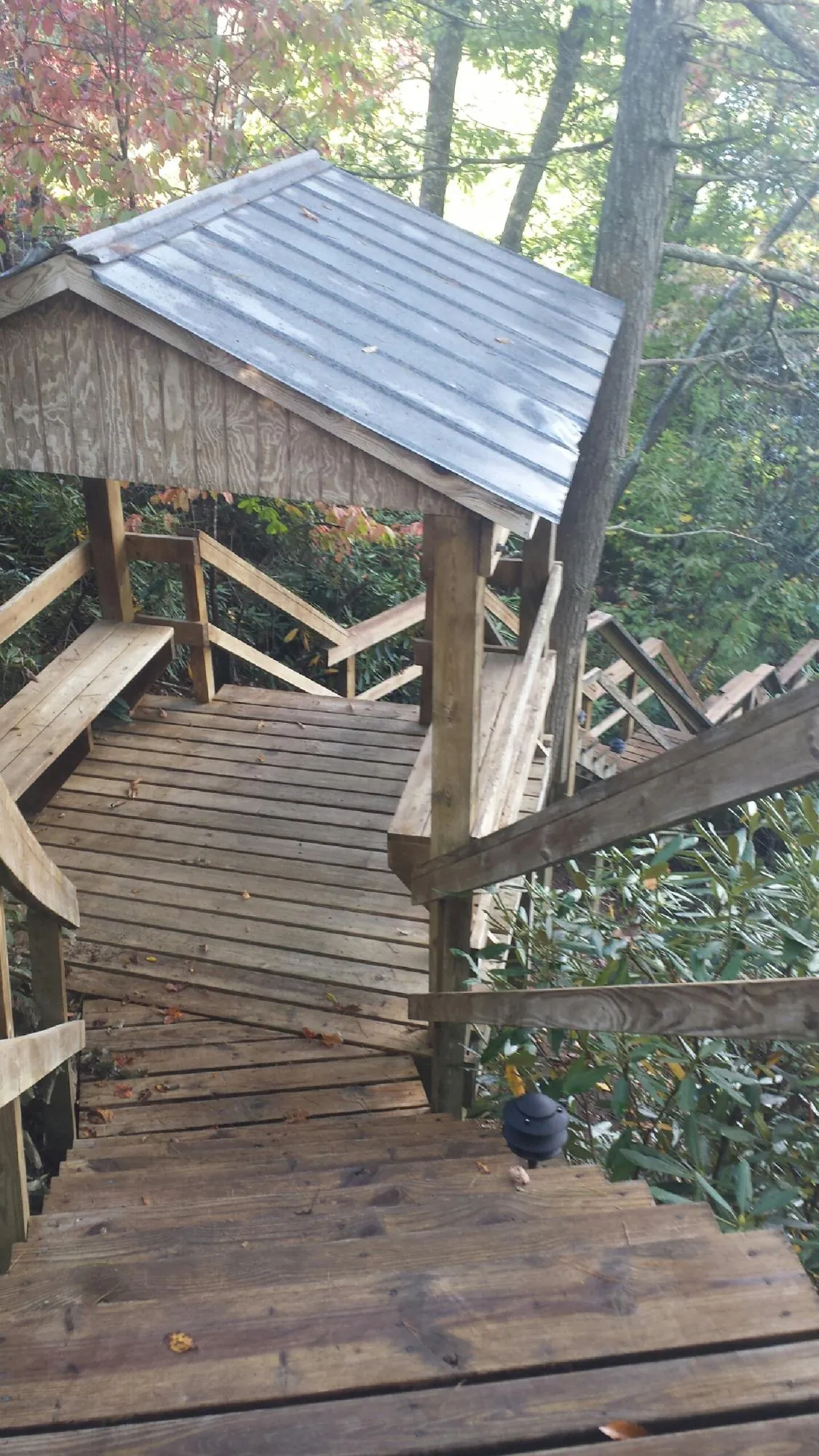 Metal roofed shelter over wooden steps on a wooded walkway — Skylight Repair & Installation work by our crew in South River