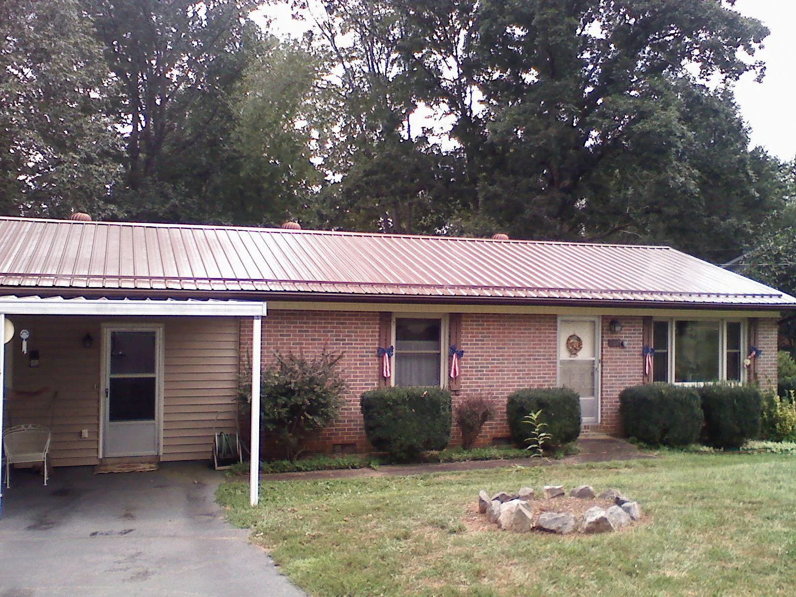 Bronze metal roof and carport on a brick ranch home — Roof Repair work by our crew in South River